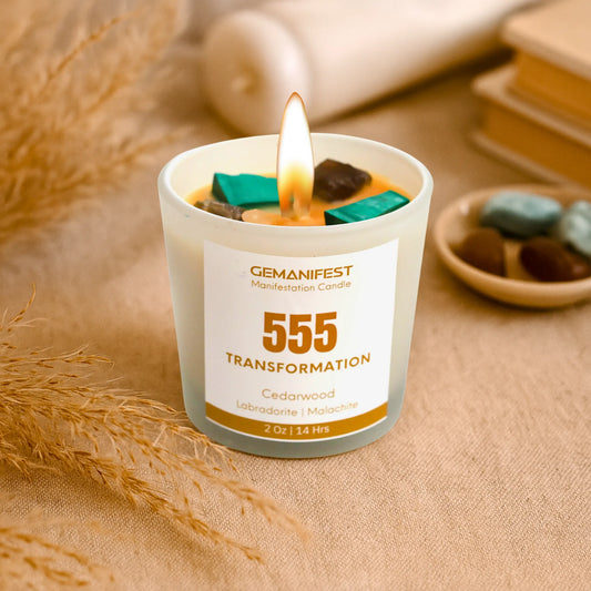 Gemanifest 555 Transformation candle on a textured surface with decorative elements.