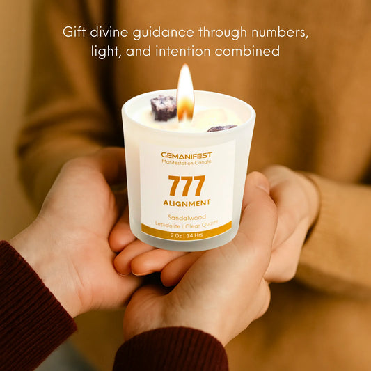 Gemanifest 777 Alignment candle on a textured surface with sandalwood and clear quartz stones.