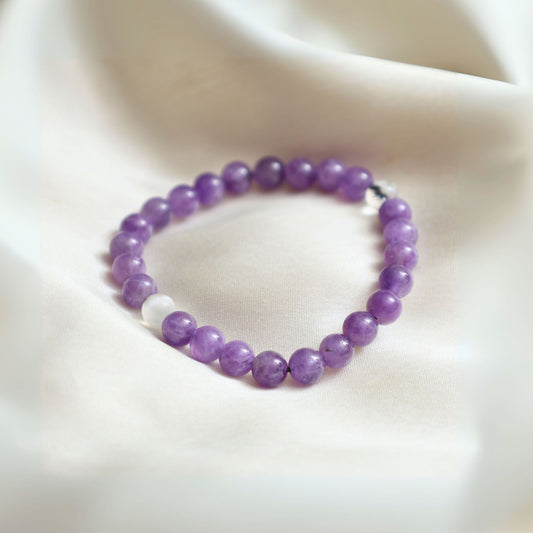Amethyst bracelet on a stone with Calm background and 'GEMANIFEST' branding