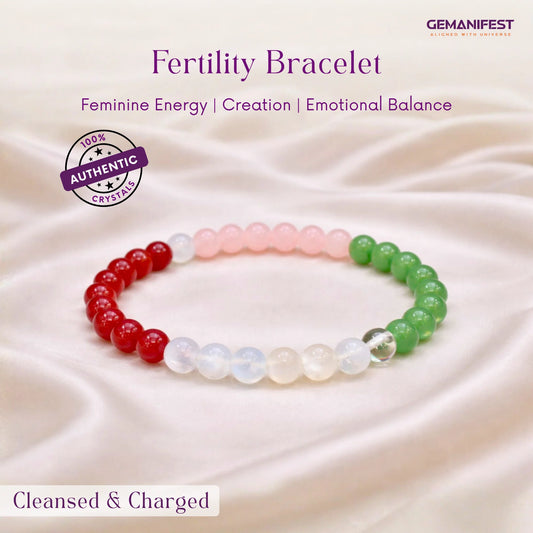 Fertility bracelet with red, white, and green beads on a soft fabric background
