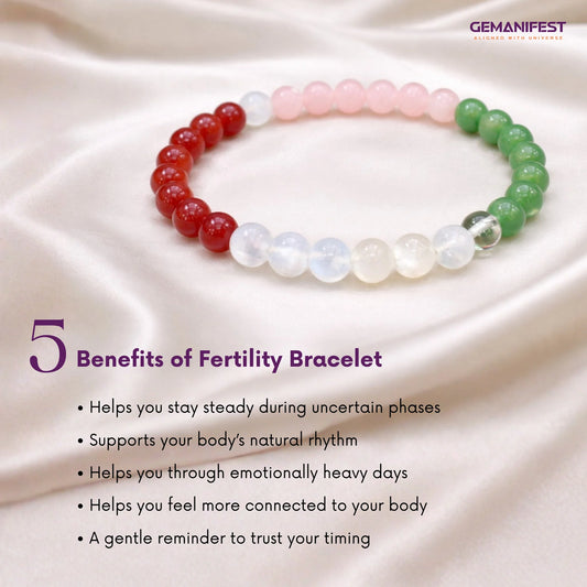 Fertility bracelet with red, white, and green beads on a soft fabric background