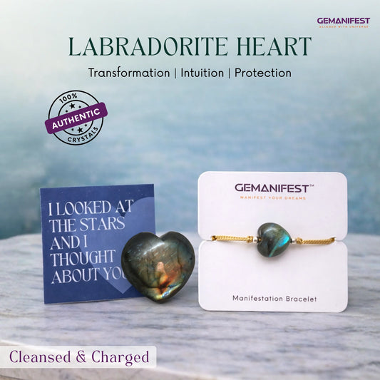 Labradorite heart stone and bracelet on a marble surface with 'GEMANIFEST' branding.