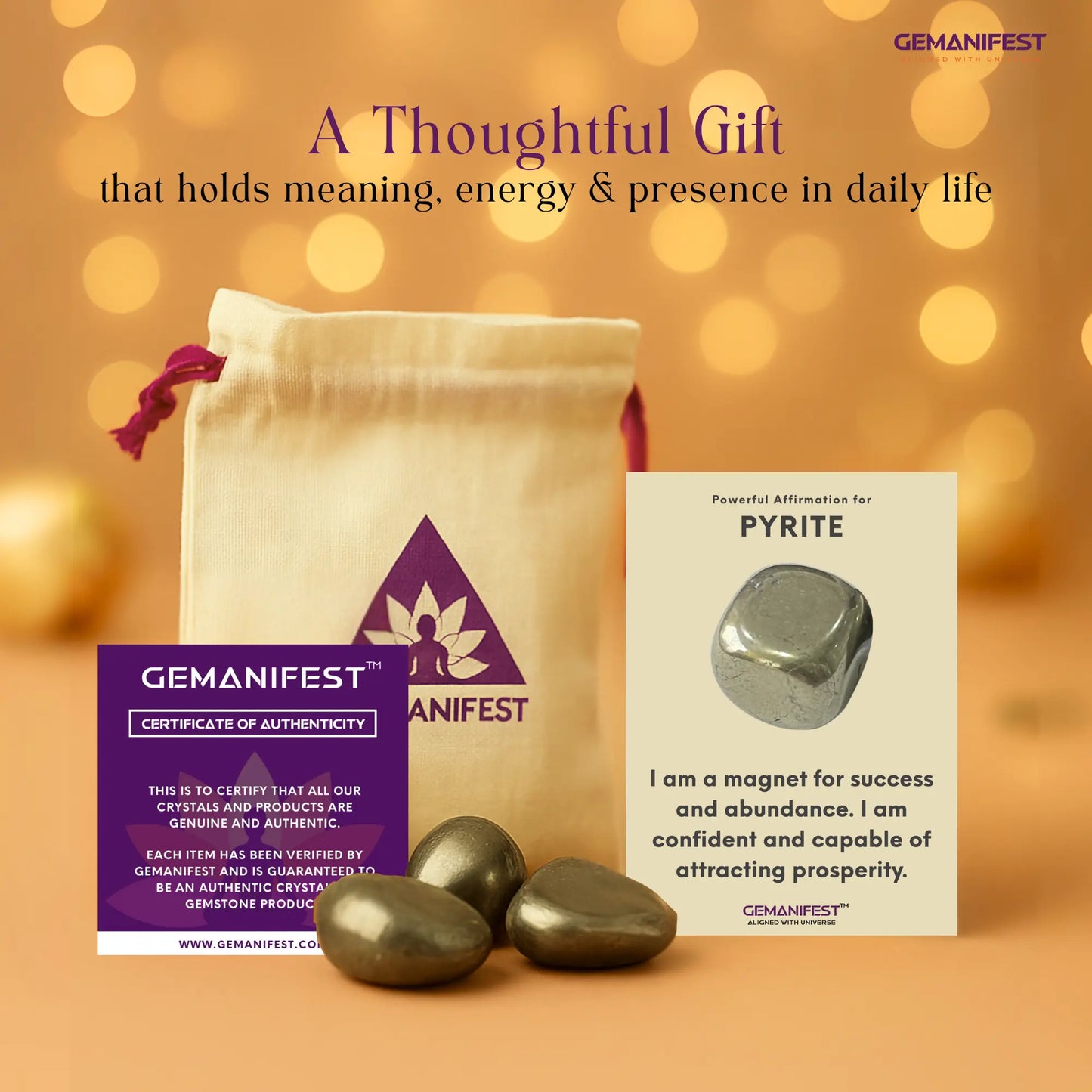 GEMANIFEST pyrite Tumble set with packaging and affirmation card on a warm background
