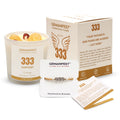 Candle with '333 Manifestation Candle' label on a surface with icons and text about soy wax, essential oil, and burn time.