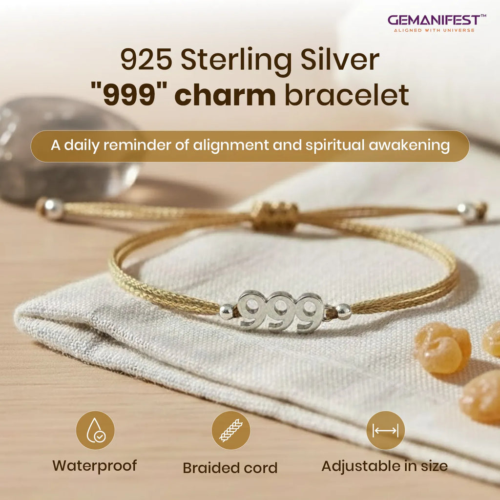 925 Sterling Silver '999' charm bracelet on a beige fabric background with GEMANIFEST branding.
