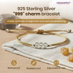 925 Sterling Silver '999' charm bracelet on a beige fabric background with GEMANIFEST branding.