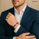 Man wearing a dark blue suit with a white shirt and a Amethyst bracelet, with 'GEMANIFEST' branding.