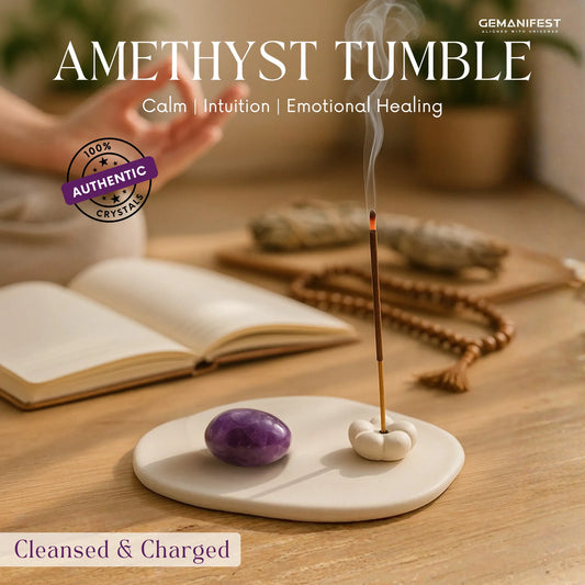 Amethyst tumble stone on a ceramic dish with incense and books in the background, featuring GEMANIFEST branding.