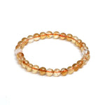 Beaded bracelet with orange and clear beads on a white background