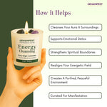 GEMANIFEST Energy Cleansing candle held by a hand with benefits listed on a green background