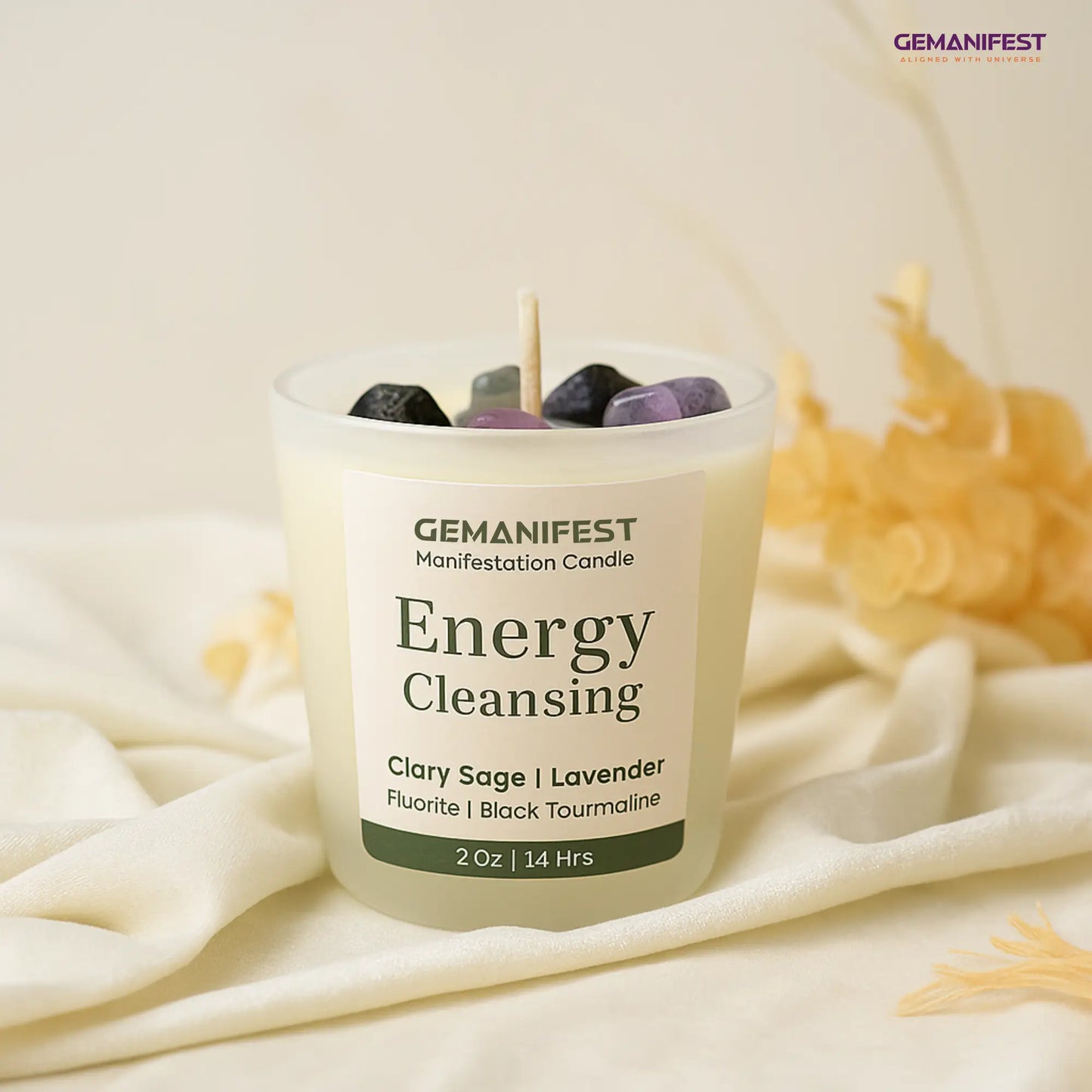 Gemanifest Energy Cleansing candle with stones on a white fabric background