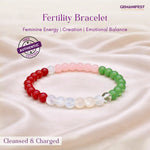 Fertility bracelet with red, white, and green beads on a soft fabric background