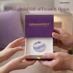 Two hands holding a box with a Fluorite Coin, branded 'GEMANIFEST', against a blurred indoor background.