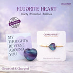 Fluorite heart crystal with GEMANIFEST packaging on a soft background