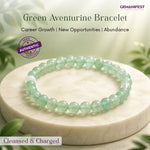 Green aventurine bracelet on a white stone surface with greenery in the background, featuring GEMANIFEST branding.