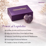 Purple gemstone box with a heart-shaped lepidolite crystal on a light background, featuring Gemanifest branding.