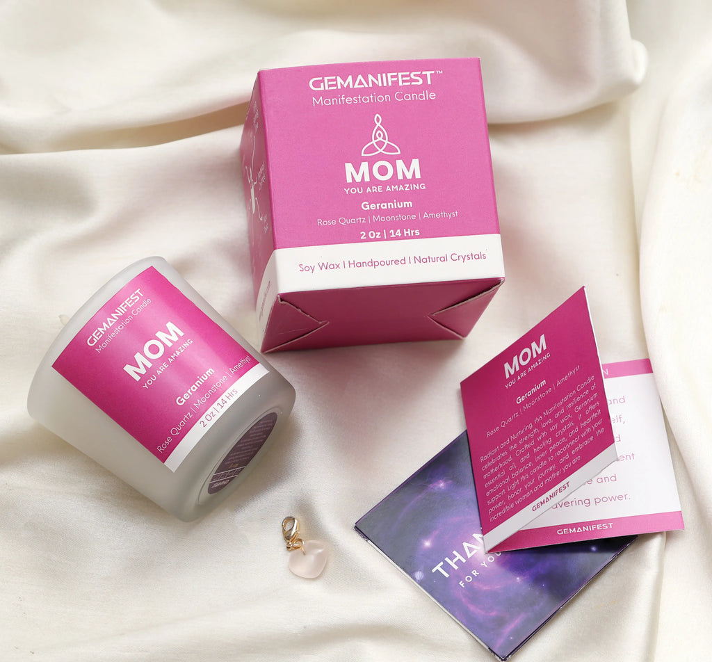 Gemanifest 'Mom' candle and packaging on a soft fabric background