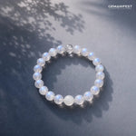 Beaded bracelet on a dark surface with leaf shadows