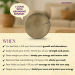 Decorative Pyrite Coin with motivational text on a blurred indoor background