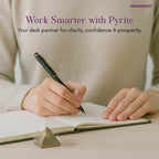 Person writing in a notebook with a pyrite Pyramid on a desk, promoting clarity, confidence, and prosperity.