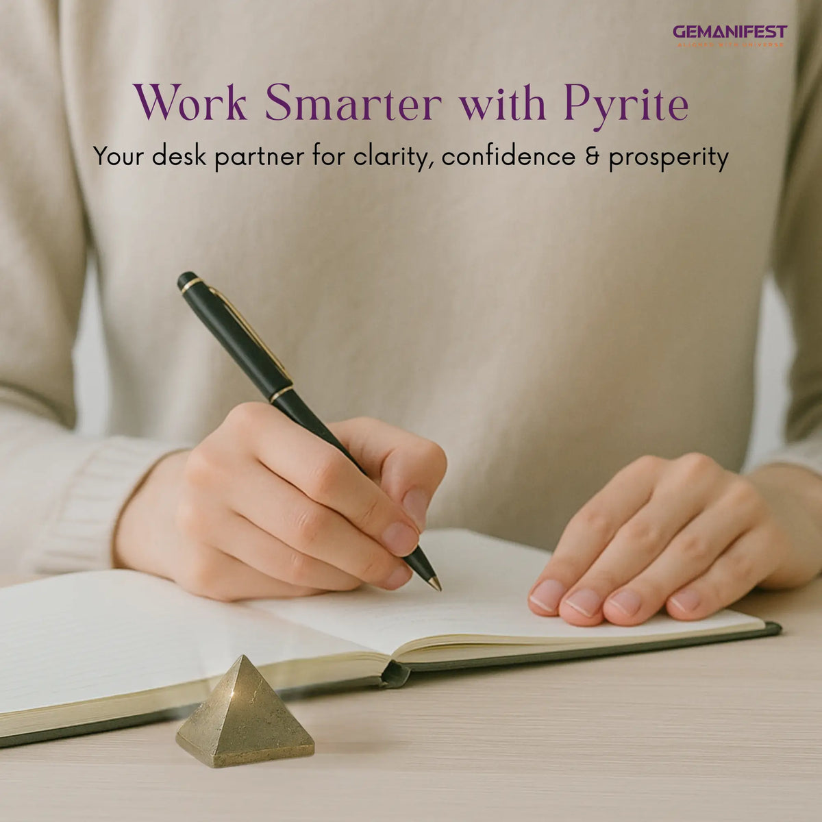 Person writing in a notebook with a pyrite Pyramid on a desk, promoting clarity, confidence, and prosperity.
