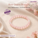 Rose Quartz bracelet on a soft fabric background with flowers, featuring GEMANIFEST branding.