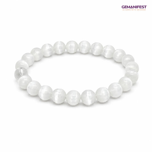 Selenite bracelet on a wooden surface with GEMANIFEST branding.